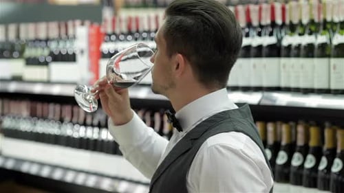 Stylish Man Tasting Red Wine Indoors