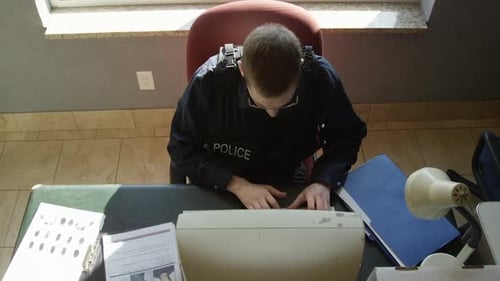 Police officer top view typing on computer HD