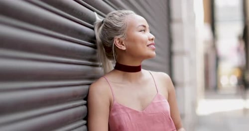Smiling woman with blonde hair leaning on wall