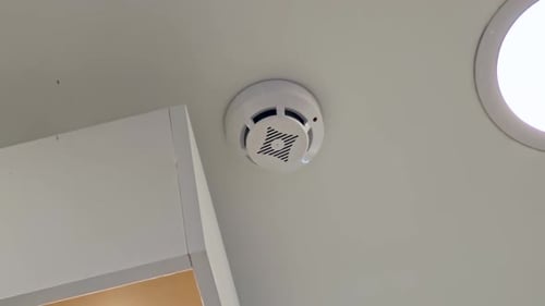 Smoke Detector Blinking on White Ceiling