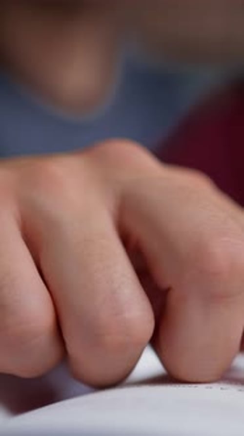 Closeup Sequence of a Young Boy Wearing a Maroon Shirt Focused on Writing on White Paper with a Pen