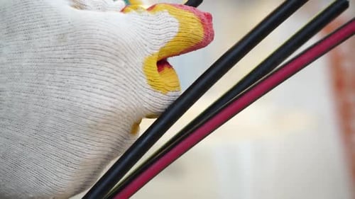 Hands Using Wire Cutters on Electrical Wires