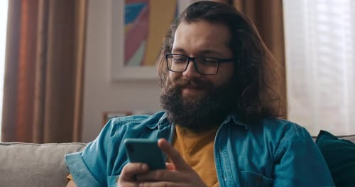 Man With Long Hair Using Phone Indoors