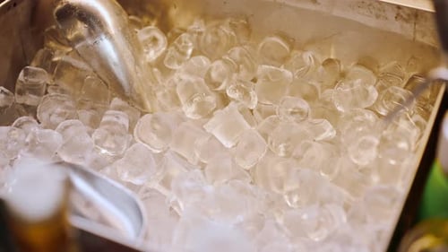 close-up of cooler with ice cubes and spatula in bar equipment for making cocktails