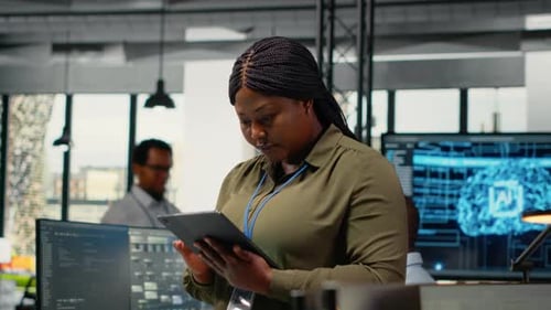 Портрет улыбающегося инженера, работающего в офисе с использованием специализированного оборудования искусственного интеллекта