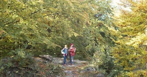 Portrait of Happy Caucasian Couple of Hikers Standing Outdoor in Forest Beautiful Woman Pointing