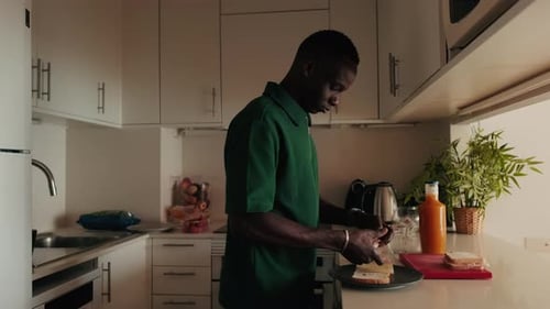 Side view of the Man Making a Sandwich in a Modern Kitchen
