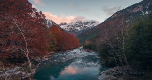 Zeitraffer bei Sonnenuntergang im Bujaruelo-Tal mit schneebedeckten hohen Gipfeln, farbenfrohen Herbstbäumen und unberührten Bergen