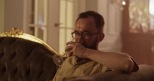 Man with Beard Drinking Wine on Couch