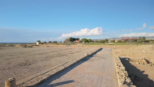 Une vue imprenable sur un site archéologique de Paphos, avec des ruines anciennes et des sentiers en pierre sous un