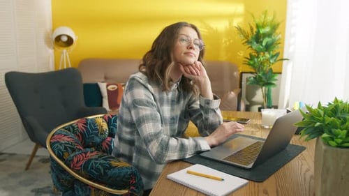 Woman Working from Home at Laptop Thinking