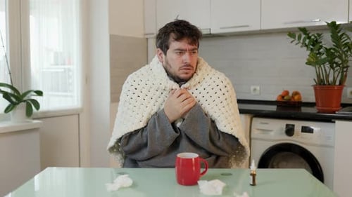Man With a Cold Sitting in Kitchen