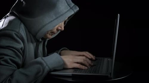 Person Wearing Hoodie Typing on Laptop