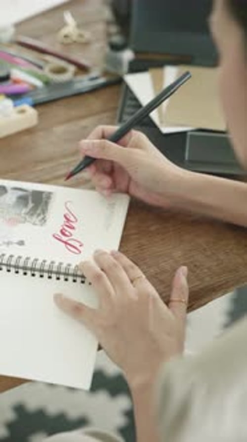 Artist Writes the Word Love in Notebook