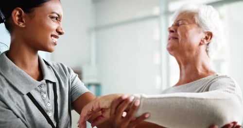 Friendly Therapist Helps Senior Woman with Arm Exercises