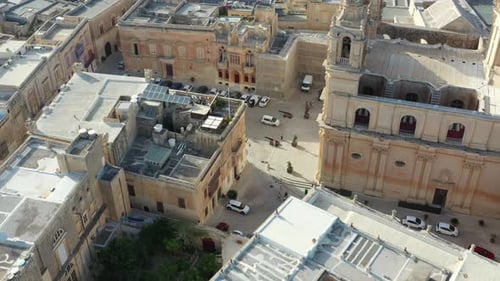 Flying high over Malta's Mdina Fortress city revealing landscape and horizon in the background. Pull