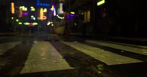 Urban Street at Night Illuminated By Neon Lights and Reflecting Rain