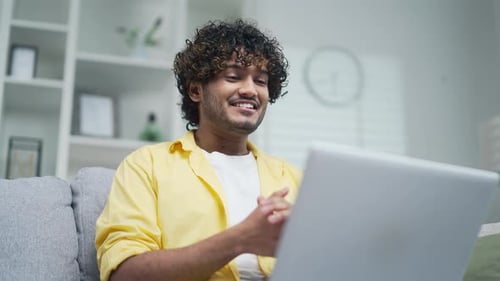 Young Adult Video Calling on Laptop at Home