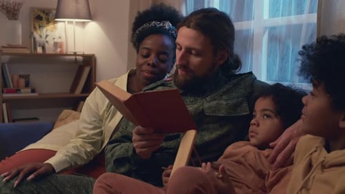 Family Together Reading a Book in Living Room