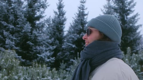 Woman Enjoying Winter Scenery in Snowcovered Forest