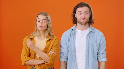 Couple Arguing With Disagreement on Orange Background