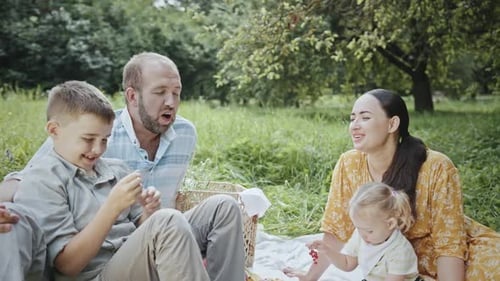 A Young Family Relaxes on a Picnic in a Summer Park Nice Conversation with your Son and a Happy