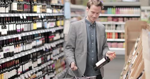 Adult male choosing wine in grocery store