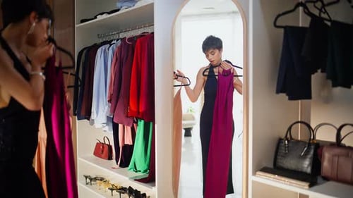Woman Deciding Between Evening Dresses in Spacious Wardrobe