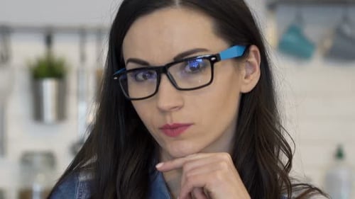 Pensive Woman in Glasses with Hand on Chin
