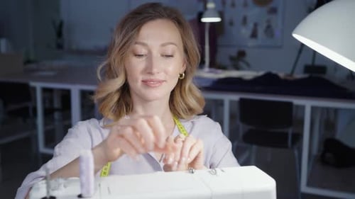 Fashion Designer Woman Seamstress Using Sewing Machine in Modern Studio