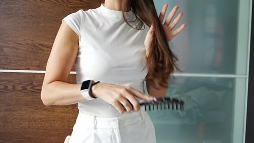 Woman Brushing her Long Brown Hair Indoors