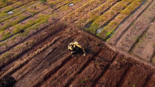 Aerial view of a wheel loader excavator with a backhoe loading sand into a heavy earthmover