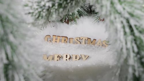 Saludos de feliz Navidad, letras de madera en un bosque de pinos nevados en un soleado día de invierno