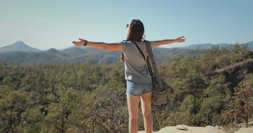 Woman Standing on Mountain Top with Outstretched Arms