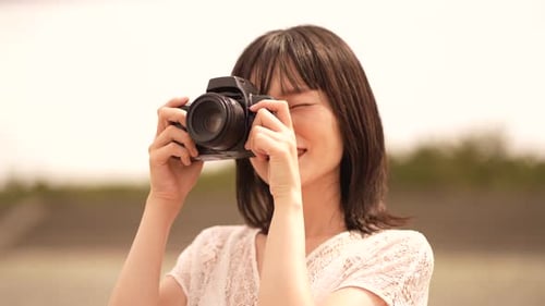 Happy Woman Taking Photo with Camera Outdoors