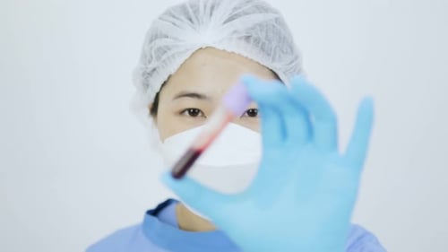 Medical Professional Holds Blood Sample Vial Close Up
