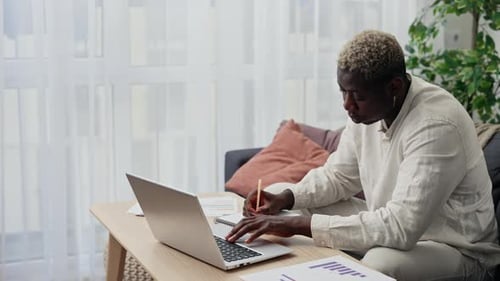 Man Working at Laptop From Home on Couch