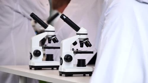 Students in Lab Coats Using Microscopes for Science Education