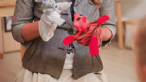 Close Up Adult Using Puppet Toys to Entertain Children