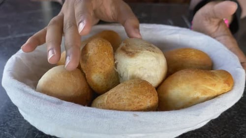 Frisch gebackene Brötchen werden in einem Korb auf einem Tisch serviert
