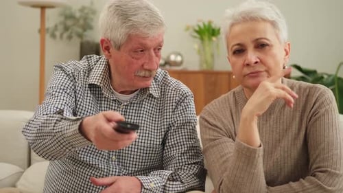 Senior Couple Relaxing on Couch, Using Remote