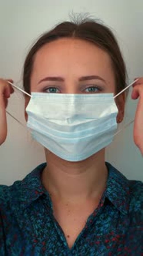 Woman Removing Blue Surgical Mask in Close Up
