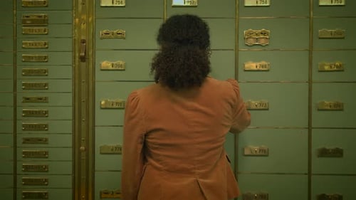 A Woman is Accessing a Safety Deposit Box in the Bank Vault to Protect Her Valuables
