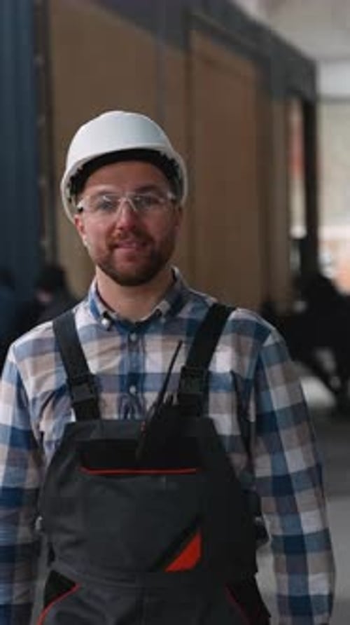 Trabajador de la construcción caminando por una fábrica de casas modulares