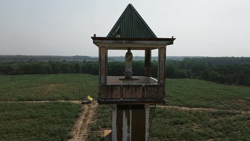 Statue abandonnée dans une ancienne tour surplombant des champs luxuriants à Tay Ninh, Vietnam