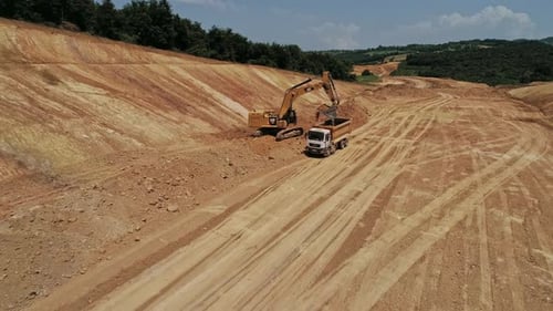 Excavator Loading Dirt into Dump Truck