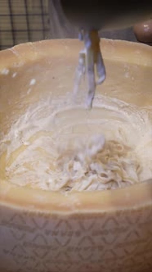 Pasta Being Prepared Inside a Cheese Wheel
