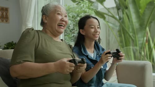 Grandmother and Teen Enjoying Video Games Together at Home