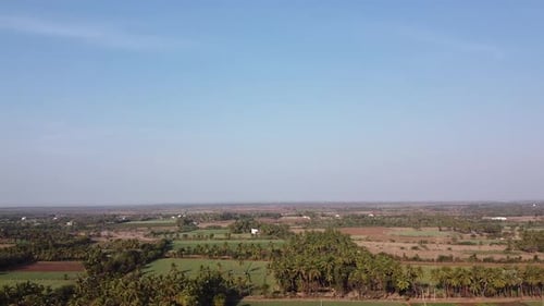 Aerial view of villages, farms, windmill farms and blue skies cinematic drone shot
