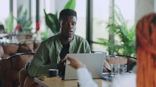 Cafe Business Meeting with Two Professional Colleagues an Afro American Man and Woman Using Modern